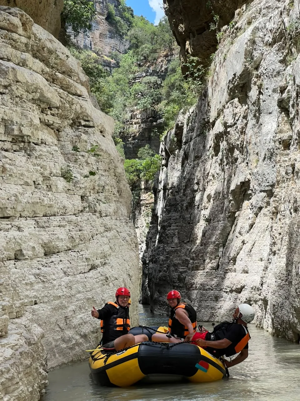 Rafter giving a thumbs up from a yellow raft in the Osum gorge